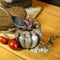 A set of pickled anchovies, in a glass jar. Fresh tomatoes and anchovy fillets on a wooden table. A jar of pickled anchovies.