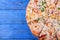 Set of pieces of different kinds of pizza on blue table. Copy space