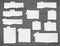 Set of pieces ripped white notebook paper are sticked on dark wooden wall or desk