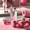Set of pink dumbbells and clear bottle filled with water laid on a pink sports mat