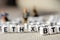 Set of popular crypto coins forming rows made of white cubes with black capital letters and miniature businessmen figurines having
