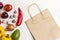 A set of products for diet food. Brown paper bag with vegetables. View from above. White background
