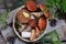 Set of red cap boletus in bowl on wooden background. Brown wild mushrooms. Edible fungus Leccinum Aurantiacum collected in forest