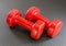 Set of red hand weights, dumbbells, lying on a black exercise yo