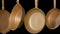 Set rustic copper fryingpans hanging on isolated black studio background. Round empty gold pans with handles