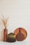 set of rustic cutting boards and ceramic brown vase on white wooden background