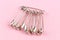 Set of safety pins lying on pink paper