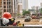 Set of safety workwear, toolbox and other professional equipment lying on stone surface against construction site