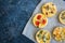 Set of savory mini tarts on a baking paper. Vegetable quiches wi