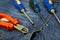 Set of screwdrivers focus in center of frame, cross multi-faceted red nippers on jeans close-up