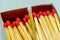 Set of several defocused red-headed matchsticks with one white-headed matchstick in evidence.
