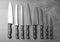 Set of sharp knives on grey background