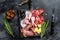 Set of smoked and dried meat Ham, jerky, salted meat, jamon and herbs. Black background. Top view