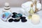 Set for spa procedures on a white marble table - aromatic oil, stones for hot massage, blue bath salt and towels, tied