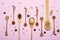 Set of spice mixes in wooden spoons on pink background. Top view, flat lay