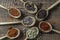 Set of spices in wooden spoons, closeup, top view. Various pepper, chili peppers, cardamom, carnation, star anise, paprika, and