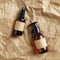 Set of spray and dispenser amber glass bottle with natural shampoo and organic lotion on crumpled paper, top view. Beauty product