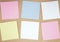 Set of square paper notes on kraft paper background. Multicolored paper sheets. Glued notes, stickers or memos. Mockup for design.