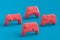 Set of standing gamer joysticks or gamepads on blue and pink background