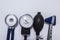 Set of stethoscope with diaphragm upwards, sphygmomanometer, air inflating bulb and neurological reflex hammer on medical table. K