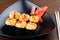 Set sushi on a black triangular plate with ginger closeup.