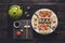 Set of sushi and rolls with teapot on black rustic wood, top view