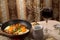 A set table for the Passover Seder with traditional matzah, wine, maror and shakshuka in a frying pan.