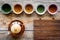 Set for tea ceremony. Glass teapot and ceramic cups on rustic wooden background top view mockup