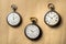 Set of three antique silver American and Swiss pocket watches with markings on beige background. Retro mechanical watch