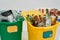 Set of three colorful green, yellow and white recycle garbage bins full of rubbish isolated on white background. Waste