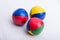 A set of three colorful juggling balls on a white surface