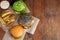 Set of three mini homemade Burger, Idaho potatoes with sauce and vegetables on a old wooden background. the concept of junk food a