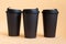 Set of three takeaway black coffee cup on neutral background natural light. Mock -up, nobody, front view