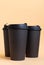 Set of three takeaway black coffee cup on neutral background natural light. Mock -up, nobody, front view, vertical