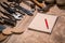 Set of tools, notebook, pencil for shoemaker on a wooden background.