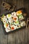 Set of traditional japanese food on a dark background. Sushi rolls mosaic pattern in wooden black frame. Vertical image