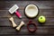 Set of treats and toys for pets with bones, collar and bowl on dark wooden background top view