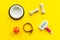 Set of treats and toys for pets with bones, collar and bowl on yellow background top view