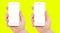 Set two different phones with blank display on yellow background, male hands hold phones