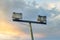 Set of two outdoor floodlight and a pole against sunset sky and clouds background with copy space