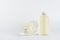 Set of two transparent plastic low thick bottles standing and lying with pale fresh drink or cosmetic essential oil and silver cap