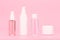 Set of unbranded cosmetic bottles with cleansing gel, face cream, lotion and under eye cream against pink background