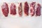 Set  of  vacuum packed organic raw beef alternative cuts: top blade, rump, picanha, chuck roll steaks, over white background, top