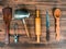 Set of various kitchen tools on old wooden table, top view. Wooden spoon, knife, rolling pin, turk for coffee laid out