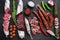 Set of various spanish dry cured salami sausages slices and whole cuts on balck background, top view