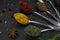 Set of various spices and herbs on black slate background. Pepper, turmelic, ginger, saffron, basil, rosemary, chilly, cardamom,