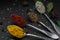 Set of various spices and herbs on black slate background. Pepper, turmelic, ginger, saffron, basil, rosemary, chilly, cardamom,