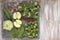 Set of vegetables on white painted plate and wooden background: kohlrabi, cucumber, apple, pepper, brussels sprouts, pea pods, bro