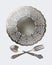 A set of vintage dinnerware: plate, crossed forks and spoons on a white background. Antique silverware. Retro style.