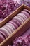 Set of violet and lilac macarons in cardboard gift box with lilac flowers